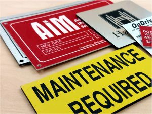 Lamacoid Sign Samples Collection of Lamacoid Signs and Labels for an Electrical Panel- Black and Yellow Safety Label, Red and White Warning Label, White and Black Nameplate, and Silver Door Sign with Black Engraving for the City of Hamilton, Ontario.