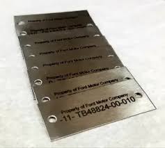 A close-up of a stainless steel machine plate with permanently laser-marked serial numbers and specifications.