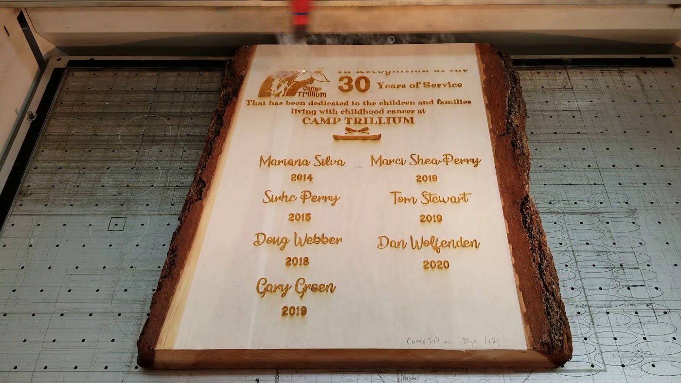 Engraved wood plaque on the laser bed at Aran Awards in Hamilton