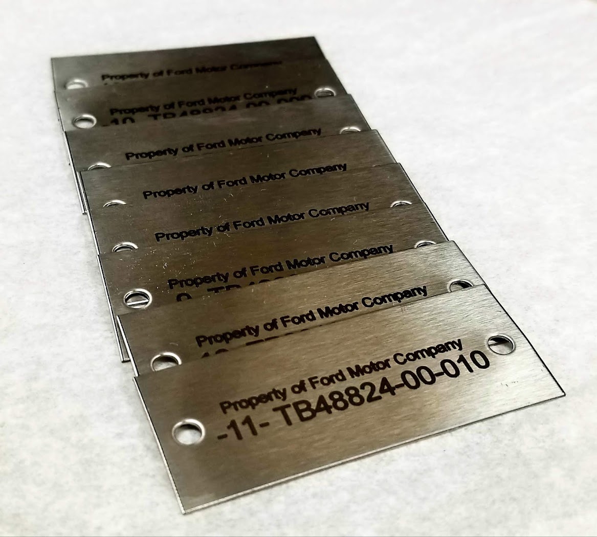 Industrial metal data plate showing compact readable technical lettering