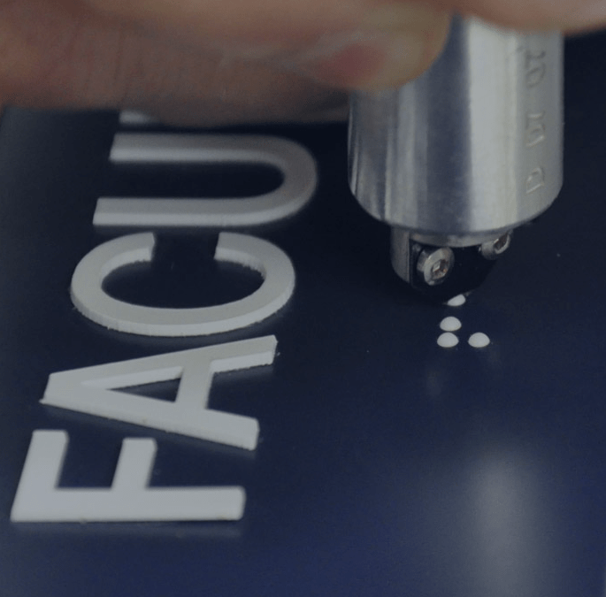 Of White Raster Braille Bead Being Inserted Into Black by Aran Awards in Hamilton, Ontario