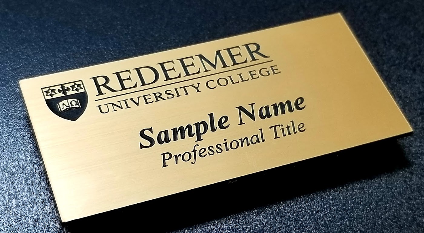Metal name tag showing clean readable sans-serif-style lettering by Aran Awards in Hamilton